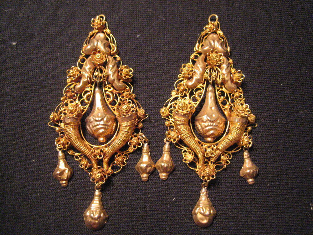 1 paar gouden oorhangers. Peervormige ornamenten van filigrain, ondergedeelte met 2 hoorns des…