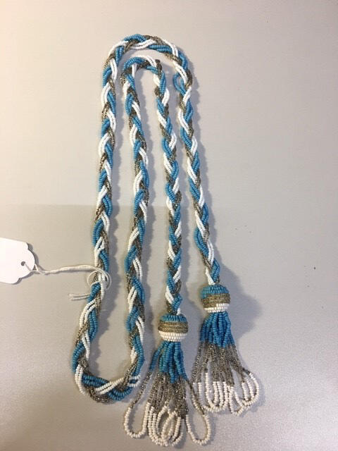 Halsketting, vlecht van blauwe/witte/zilverkleurige kraaltjes, aan uiteinden kwastjes