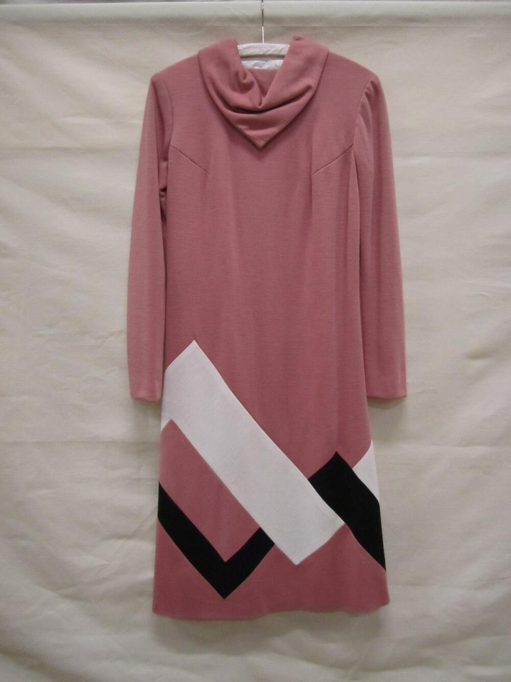 Jurk van oudroze, synthetische tricot met op de rok een witte en een zwarte ingezette, driehoekige…