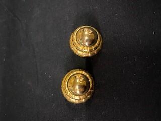 Twee oorclips van goudkleurig metaal, knop met een dubbele rand erom
