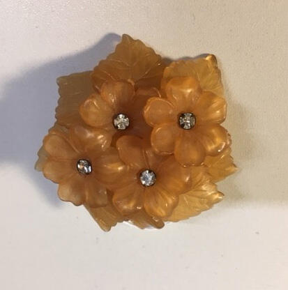 Broche, arrangement van lichtbruine kunststofbloemen en -blaadjes, bloemen met hart van witte…