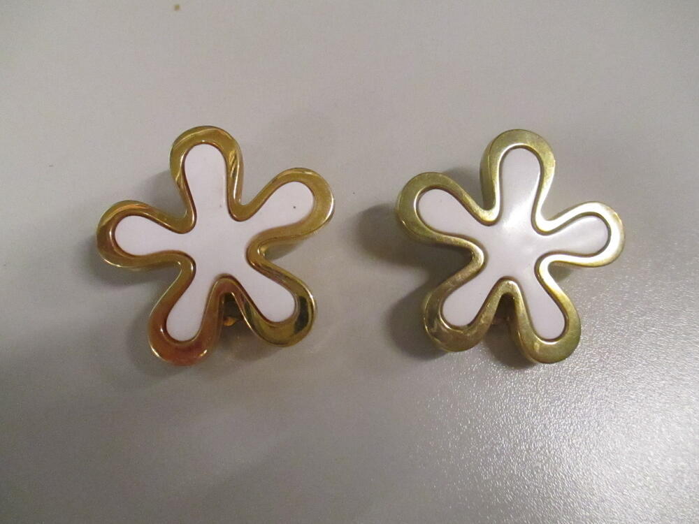 Oorclips, bloemvormig model van goudkleurig metaal met hart van wit plastic