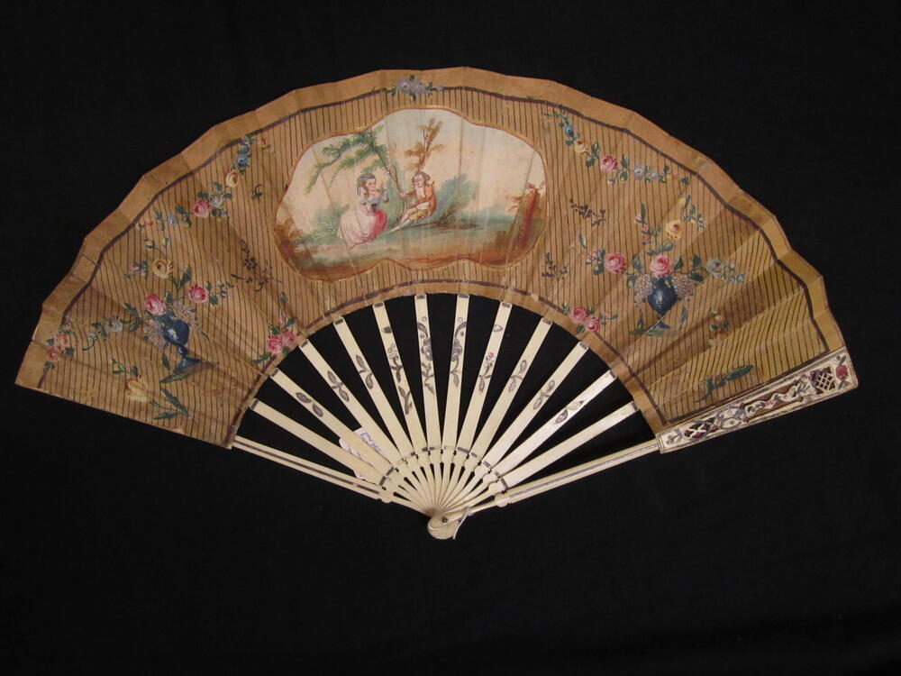 Vouwwaaier, montuur van beschilderd been, blad van bruin papier met centrale cartouche waarin…