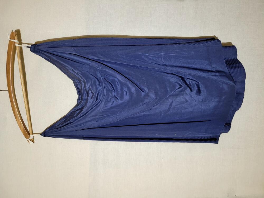 Rok van blauwgrijze zijde met glad voorpand en achterpand met mini plissé's, elastiek in de taille