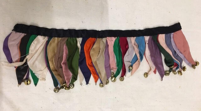 Beenversiering. Onderdeel van harlekijnpak van veelkleurige zijde met belletjes, bestaande uit…