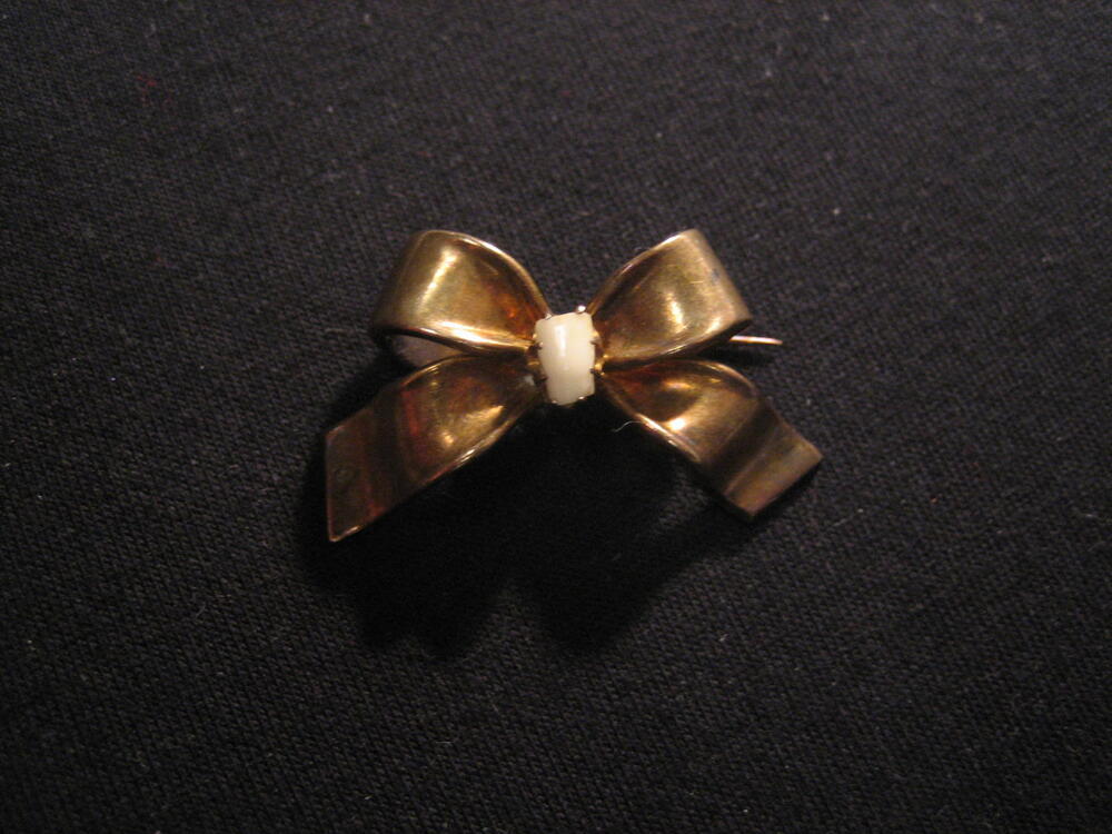 Gouden strikbroche met tandje