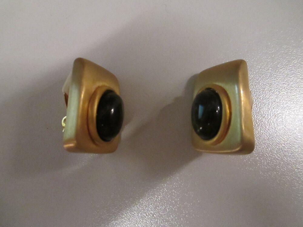 Oorclips, rechthoekig model van matglanzend goudkleurig metaal, waarop bruine glascabochon met…