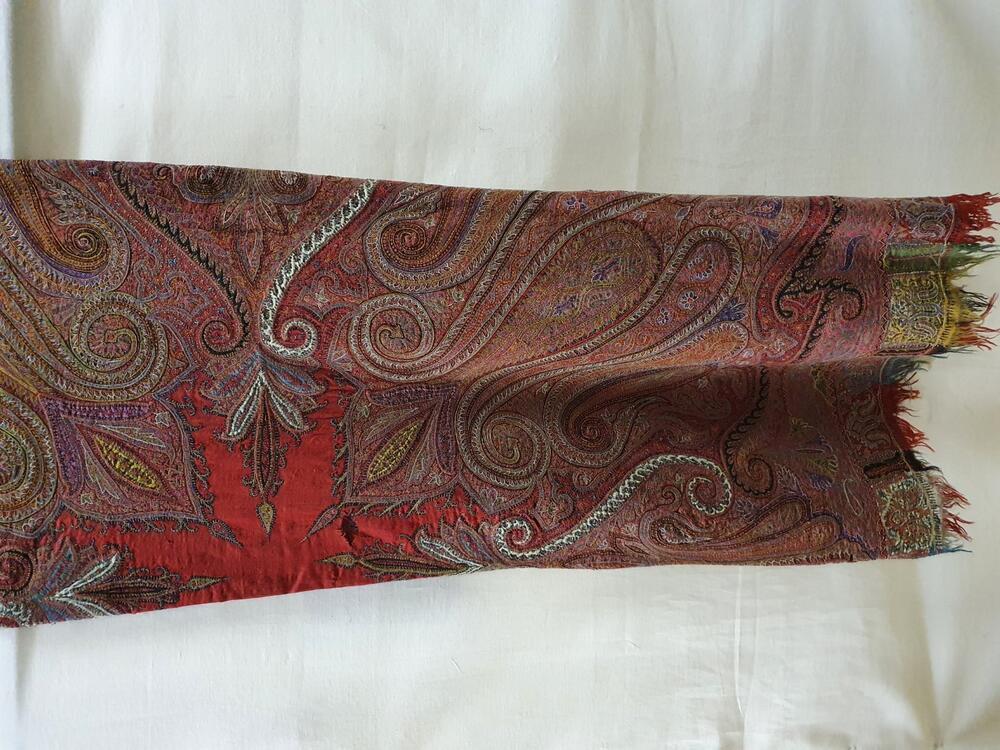 Shawl van rode wol met veelkleurig borduursel en applicaties van zwarte en witte wollen stof
