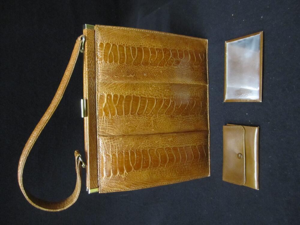 1) Handtas van bruin struisvogelleer met hengsel en metalen sluiting. 2) Beursje van bruin leer. 3)…
