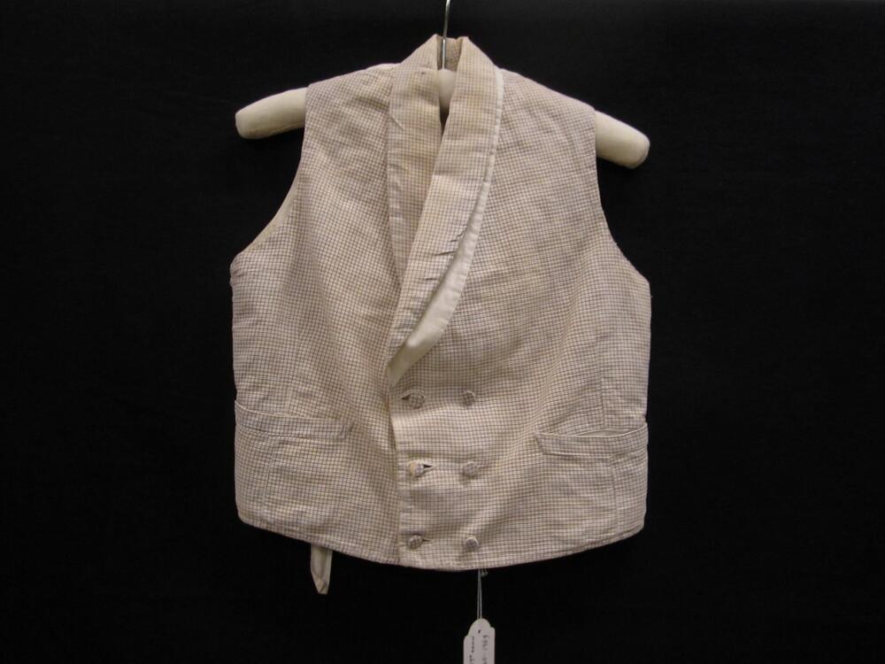 Vest (jongen) van wit katoen bedrukt met paars ruitje. Model met shawlkraag en dubbele sluiting