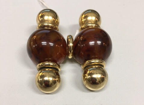 Broche van bollen imitatieschildpad en goudkleurig metaal, behorende bij oorclips