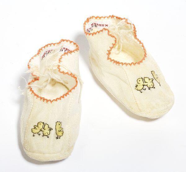 Een paar schoenen (baby), wit katoenen piquè met enkelbandjes, oranje biesje, gedecoreerd met…