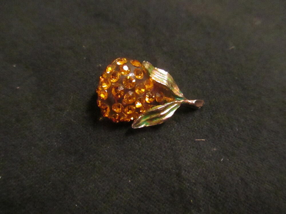 'Forbidden fruit'-broche, peervormig ontwerp van oranje plastic bezet met oranje strass-stenen,…