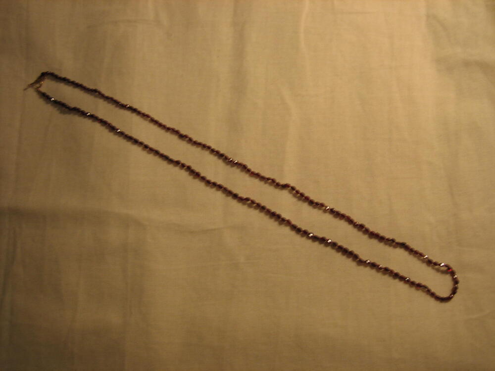 Ketting van onregelmatig geslepen granaten, geregen aan rood draad