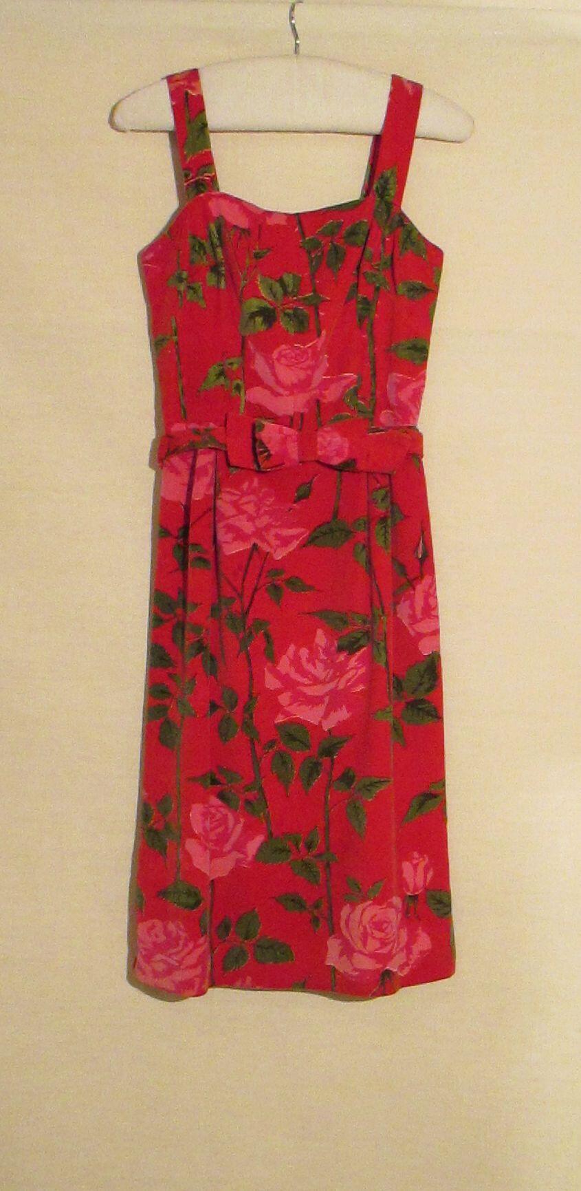 1) Avondjurk van rode fluwelen stof bedrukt met roze rozen en groen. 2) Ceintuur met strik