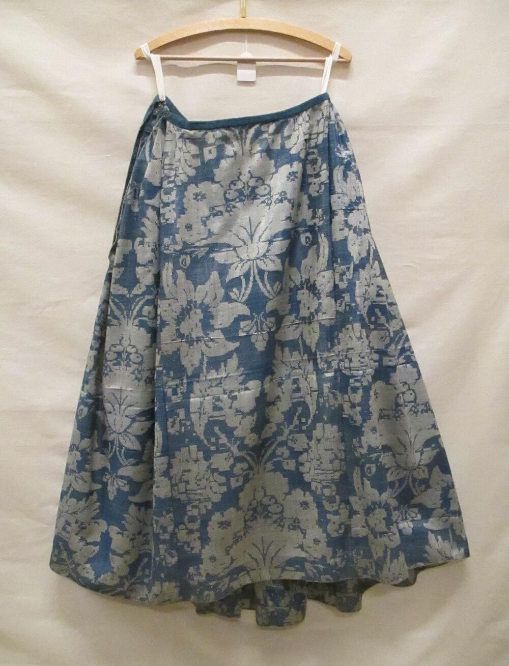 Rok van blauw en crèmekleurig wollen damast (gekalanderd) met zeer groot floraal motief, geplooid…