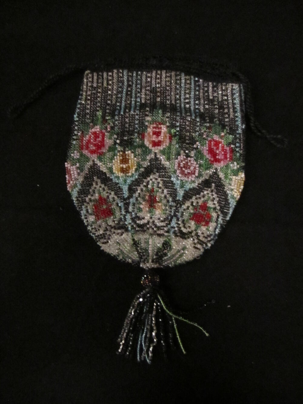Reticule, geheel bewerkt met veelkleurige kraaltjes in bloemranden. Kralenkwast aan de onderpunt