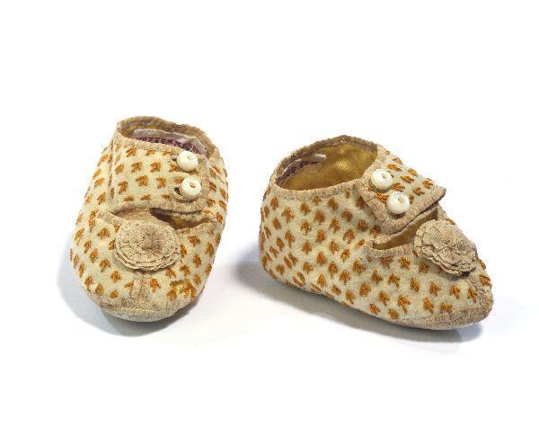 1 Paar schoentjes (baby) van wit leer en cremekleurige wollen stof met zijde borduursel in oranje…