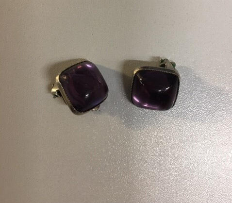 Paar oorclips. Vierkant van metaal zilver (?) met steen (cabouchon vorm) van paars glas.