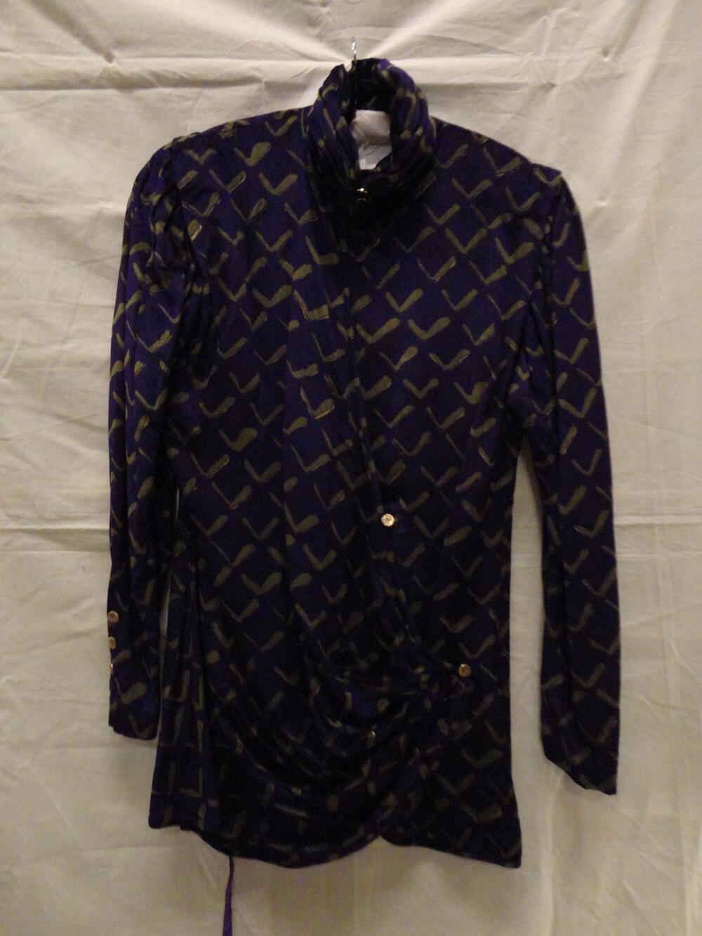 Blouse van paars fluweel bedrukt met V-vormig motief in groen en goud