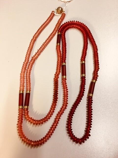 Ketting. Plastic afgeplatte kralen. 4 tinten roze, bij kleur overgangen lange kraal met…