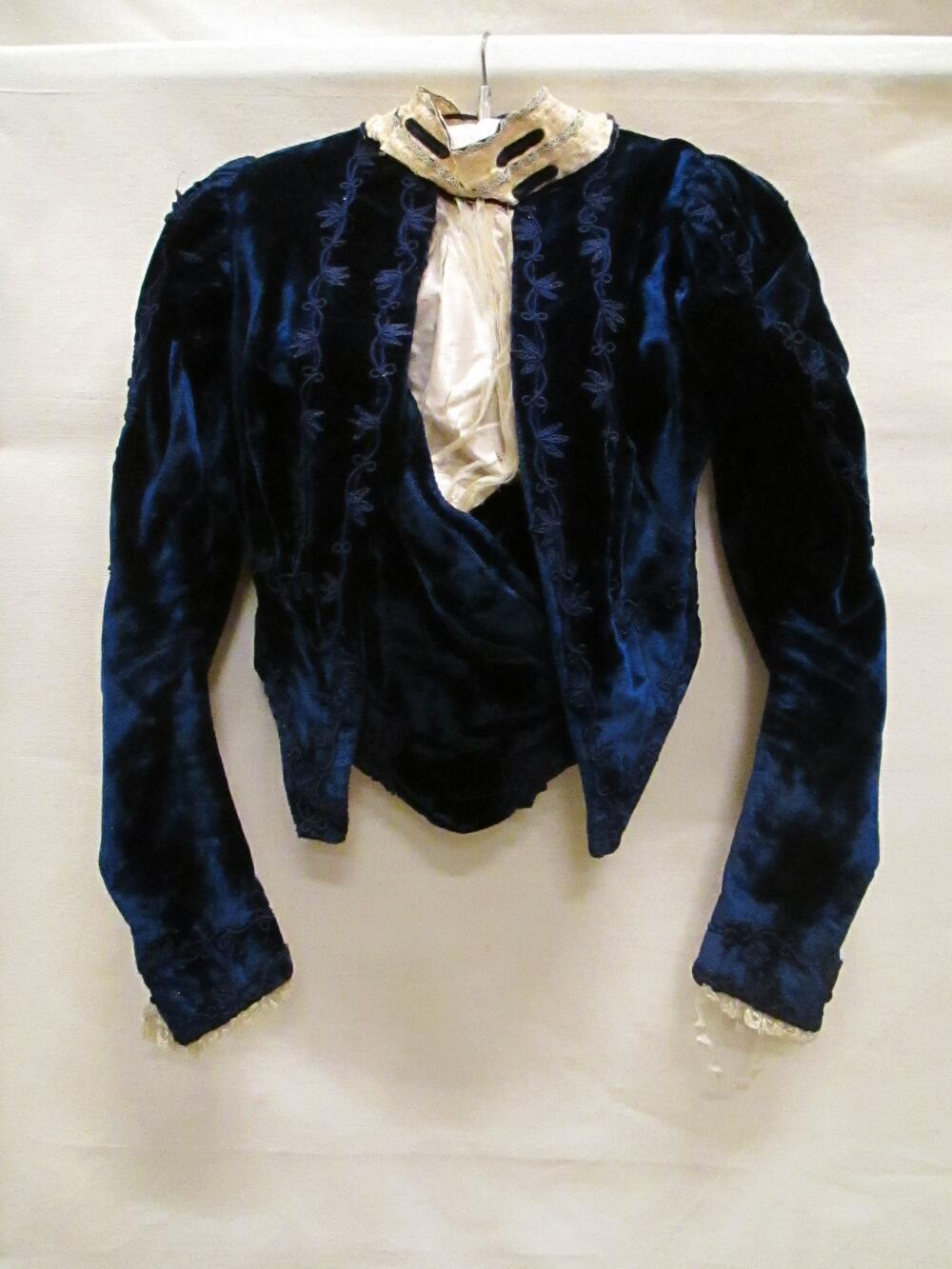 Japonlijfje, model bolero, van marineblauw fluweel met garnering van blauw trèsband en guimpe van…