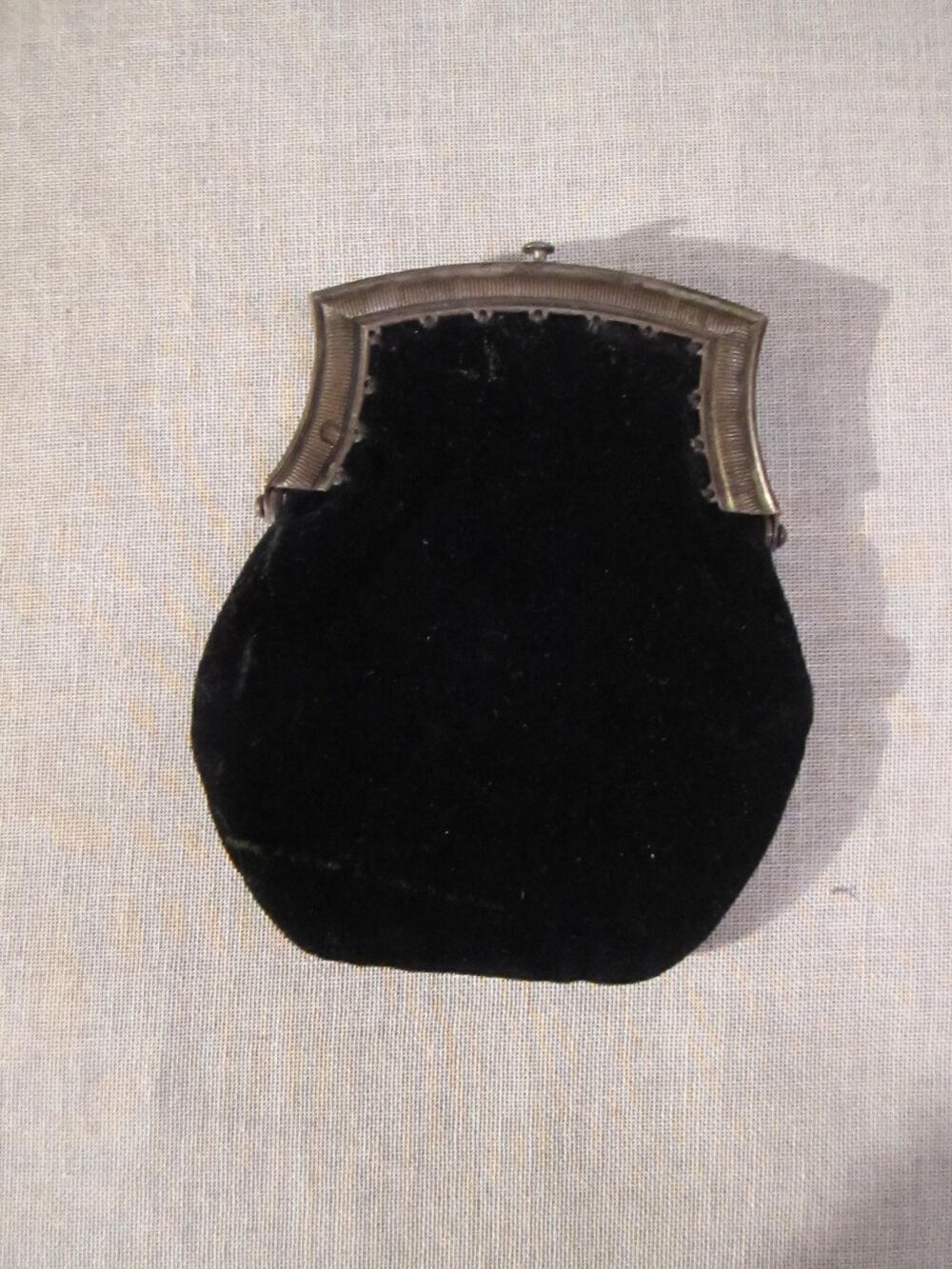Beursje. Ovale zakje. Genaaid aan beugeltje. Zwart fluweel. Beugeltje van zilver. Voering van zwart…