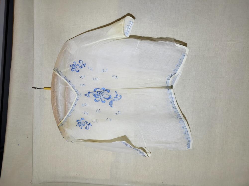 Blouse van dun wit katoen, geborduurd met blauwe zijde, schoudersluiting middels witte knoopjes van…