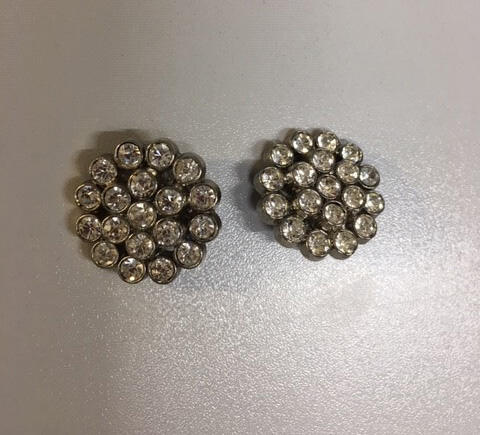Paar oorclips. Metaal zilverkleurige cirkel met strass in 2 rijen rond steen in het midden.