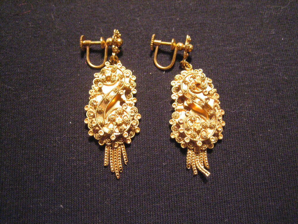 1 paar gouden oorhangers met filigrainwerk, behorende tot set. Aan bloemvorm een pendant met S-vorm…