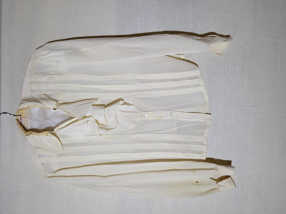 Blouse van crèmekleurige crêpezijde, jabotvormige ruche langs de hals