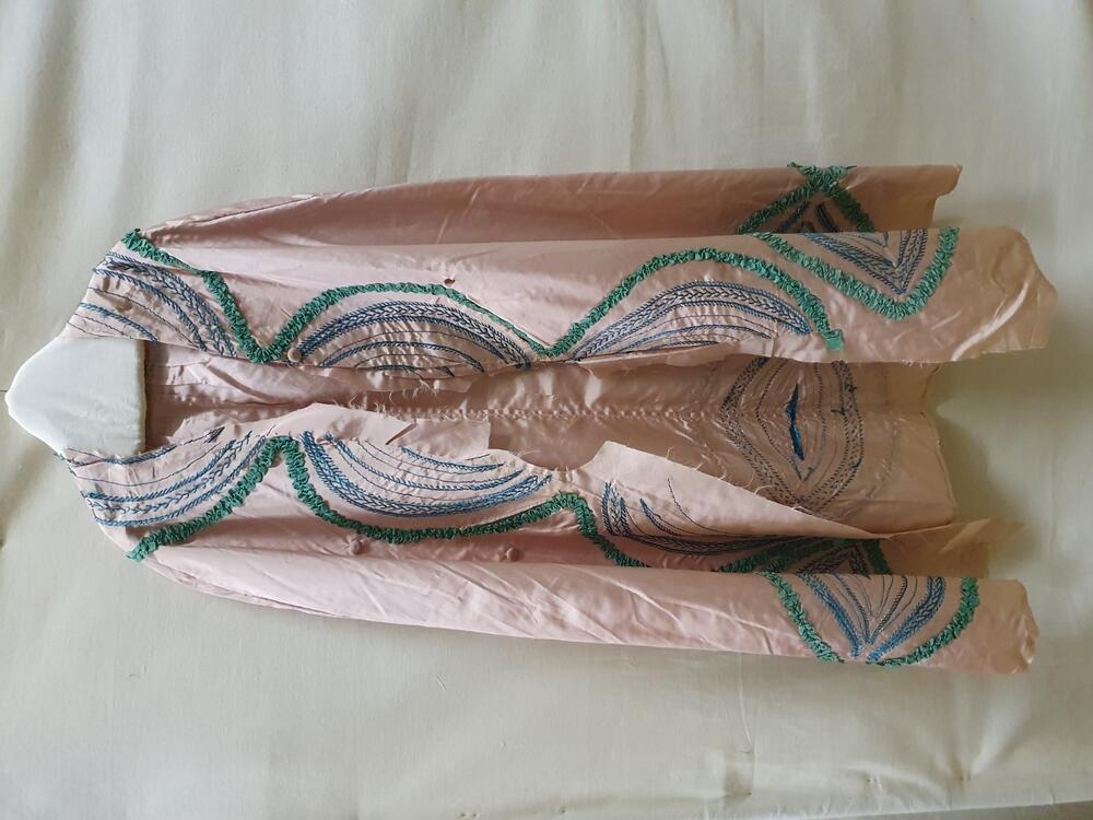 Verkleedcape van roze tafzijde met turquoise borduursel en garneringen van groen ripszijden band