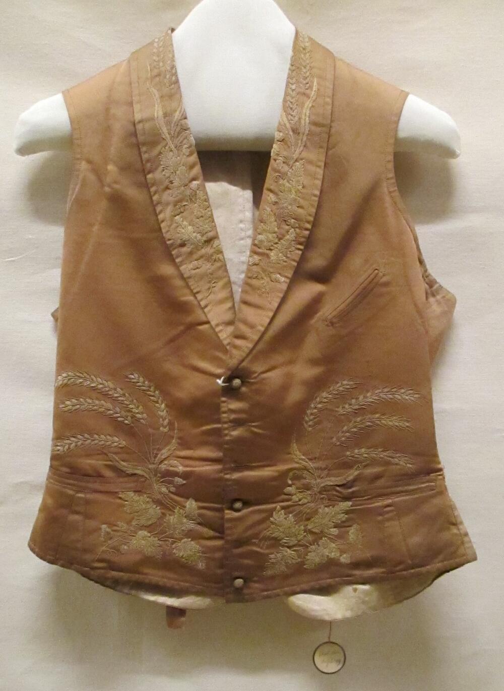 Vest (man) van bruin satijn, garnering van bladerranken van bruine borduurzijde en groen/beige…