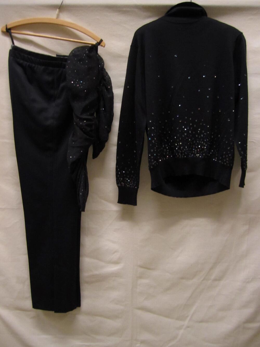 Ensemble  bestaande uit pullover, broek en sjaal. Pullover van machinaal gebreide zwarte lamswol,…