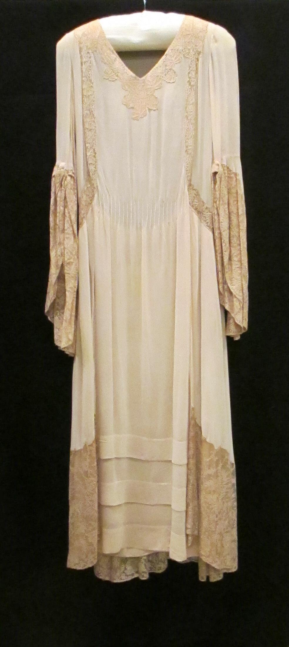 'Tea gown' van licht abrikooskleurige crêpe georgette en abrikooskleurig machinaal Mechels kant