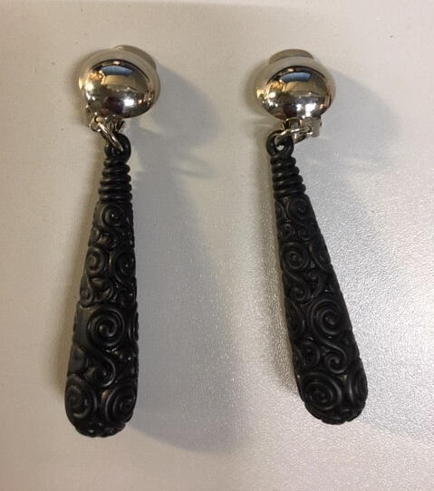 Paar oorhangers.  Metalen zilverkleurige clip met druppel van mat zwart plastic gedecoreerd met…