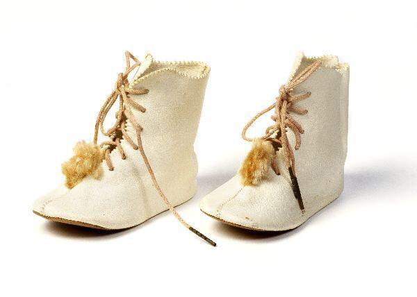 Een paar babyschoentjes van crèmekleurig wol met een grijs jute zool. Geborduurd met paars zijde…