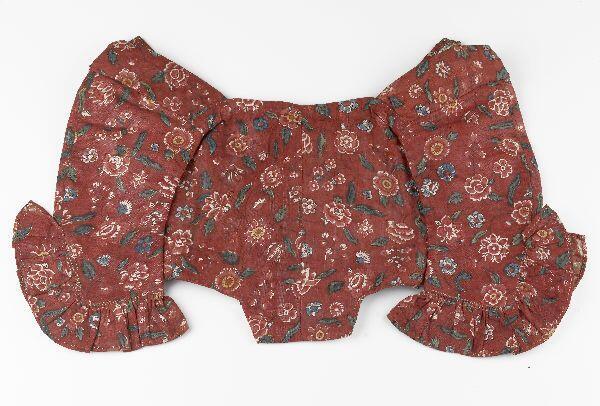 Meisjesjak van gebloemd katoen, rood fond met bloemmotieven in rood, blauw, wit, geel en groen