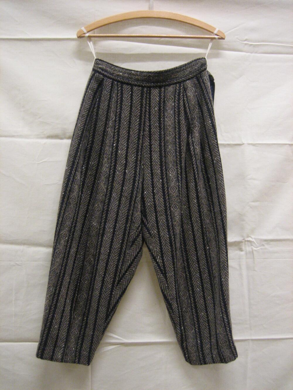 Broek van wol/katoen in beige/zwart met verticaal ingeweven visgraatmotieven en ruiten waartussen…