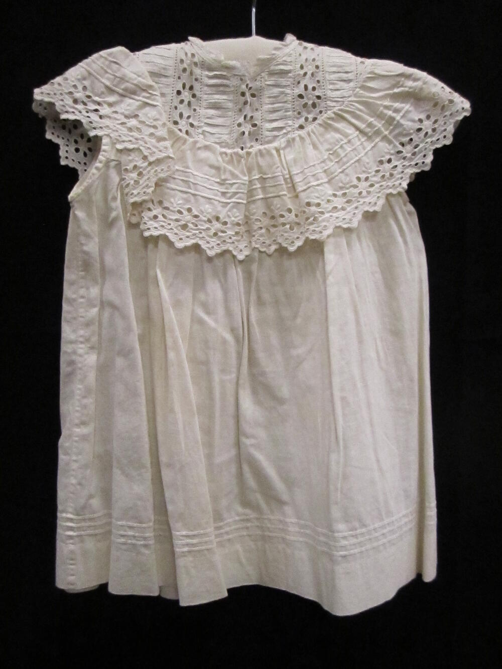 Meisjesschort van wit katoen, gegarneerd met broderie