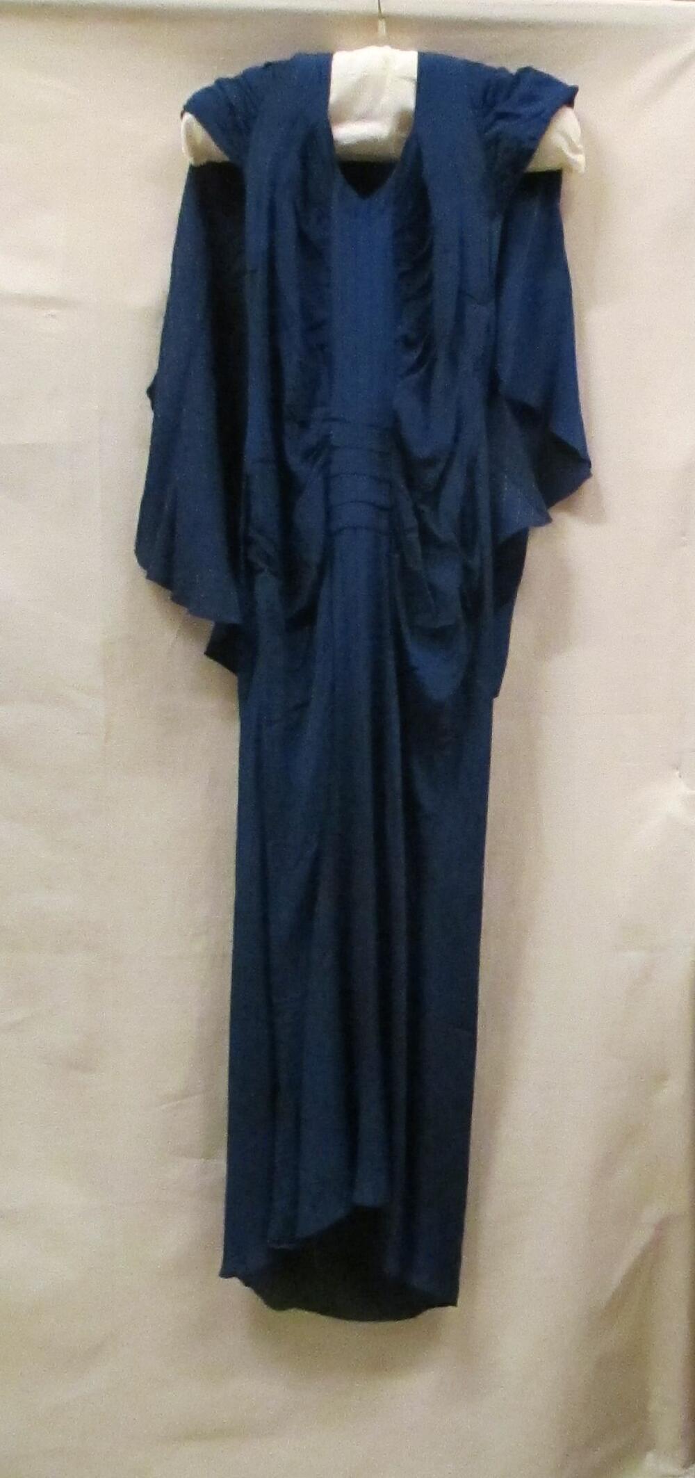 Avondjurk van blauwe kunstzijde met ingeweven streep en koperkleurig blokje, haltermodel met…