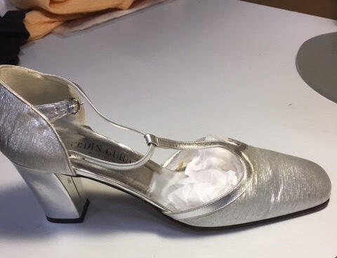 Een paar avondschoenen van zilverkleurig leer deels bedekt met zilverlamé, gespsluiting rond de…