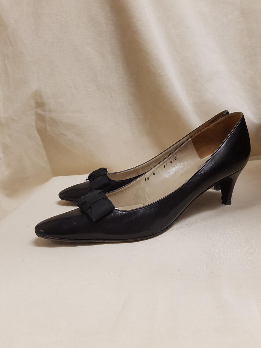 Schoenen, model 'pump' van zwart leer, met smalle neus, strik van zwarte stof op wreef en naaldhak