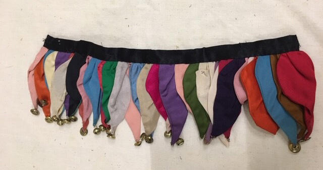 Beenversiering. Onderdeel van harlekijnpak van veelkleurige zijde met belletjes, bestaande uit…