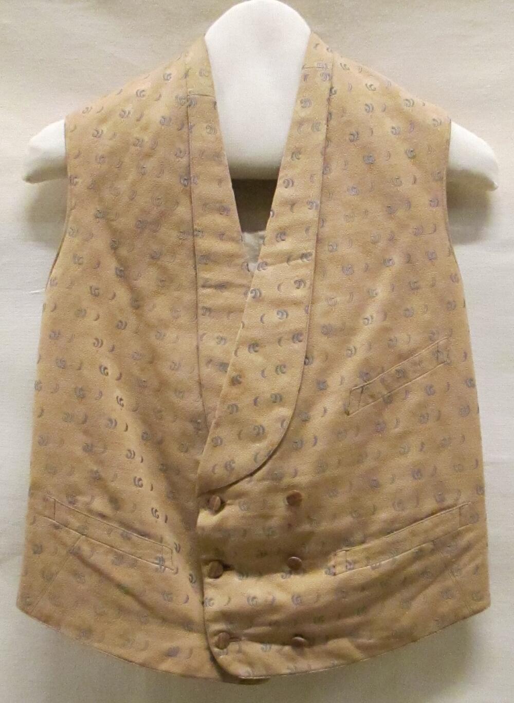 Vest (man) van beige keperkatoen met lichtblauwe kriebelstrepen/halve maantjes en ingeweven oranje…