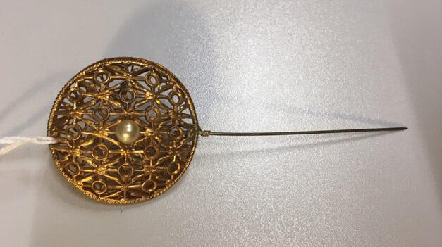 Broche, voor op revers van jasje (?),goudkleurig opengewerkt metaal (2 ronde helften op elkaar) met…
