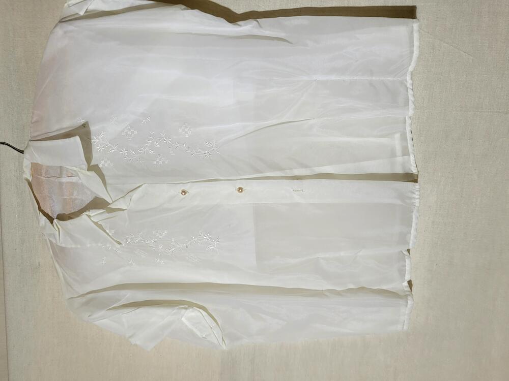 Blouse van wit nylon, geborduurd in het wit met bloemenrankjes en blokjes