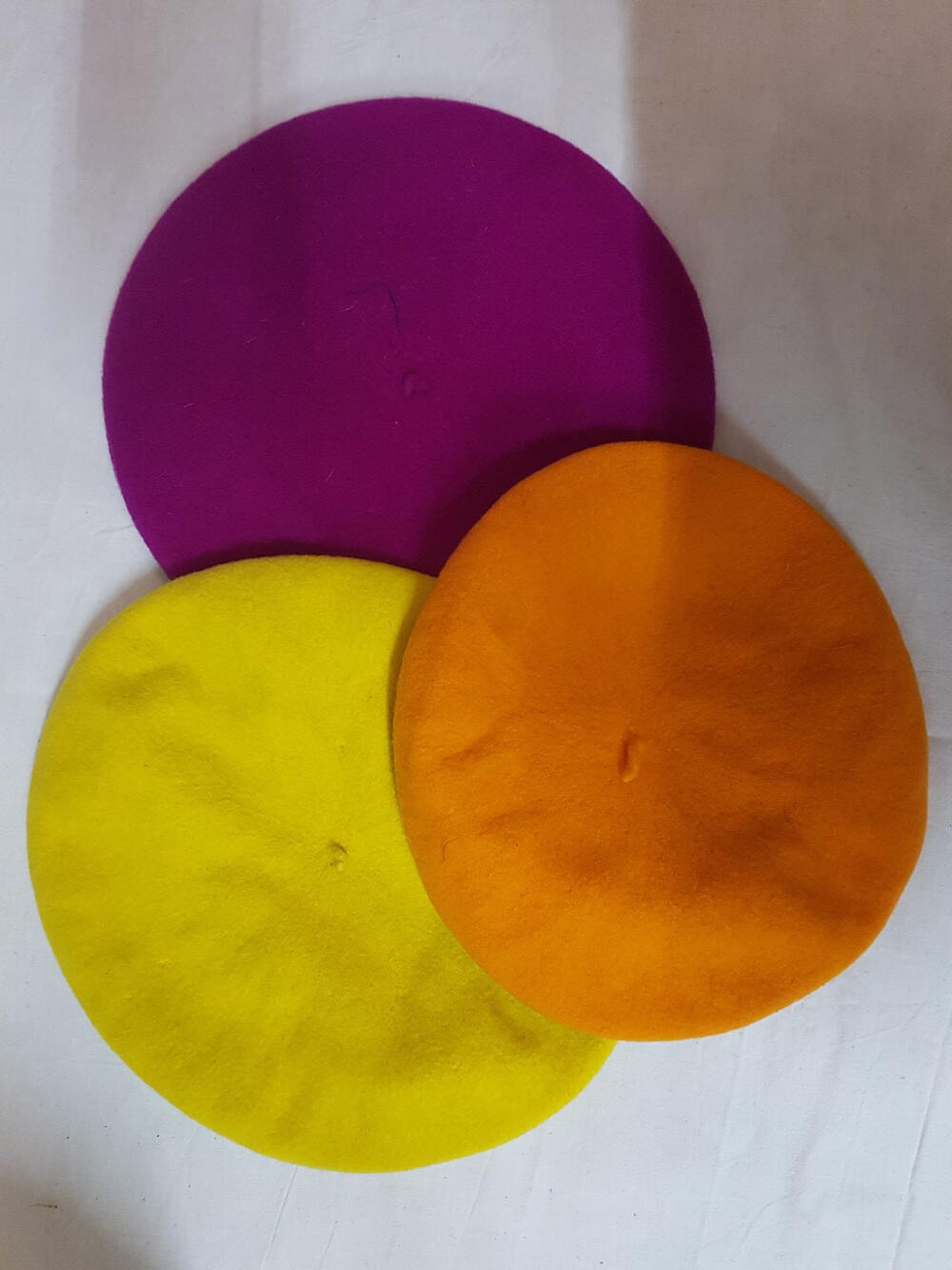 Drie baretten van verschillende kleuren wol
