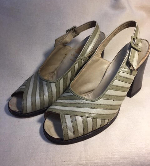 Een paar schoenen van crrèmekleurig leer bestikt met smalle reepjes beige leer, deels overlappend…