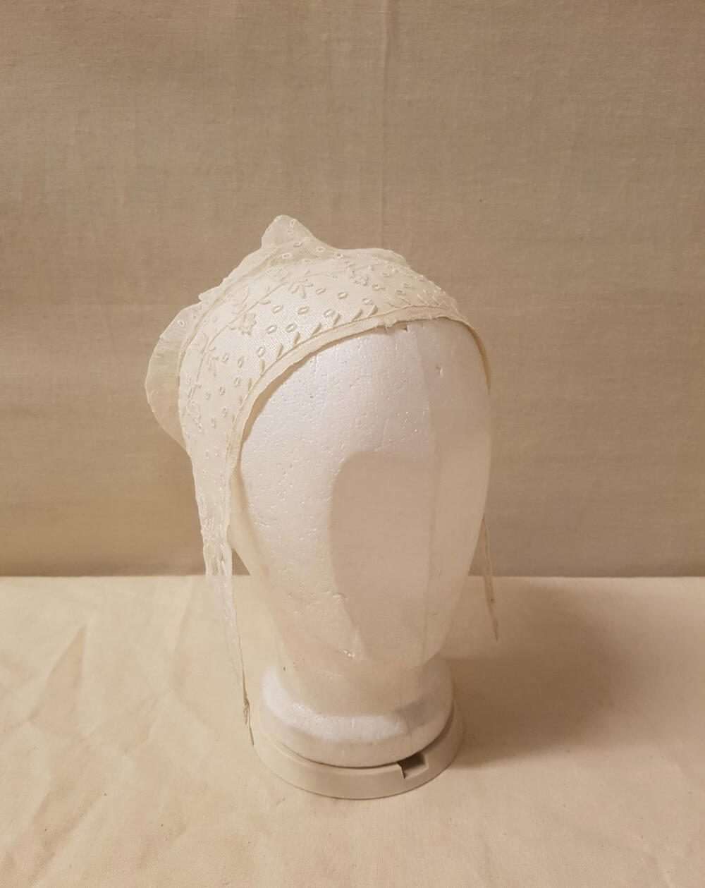 Damesmuts, witte geborduurde tule met plumetisgarnering en applicaties van neteldoek